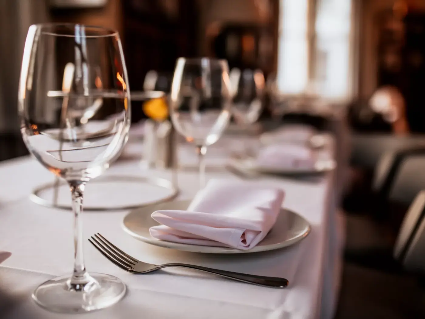 An upscale restaurant place setting with wine glasses and a linen napkin