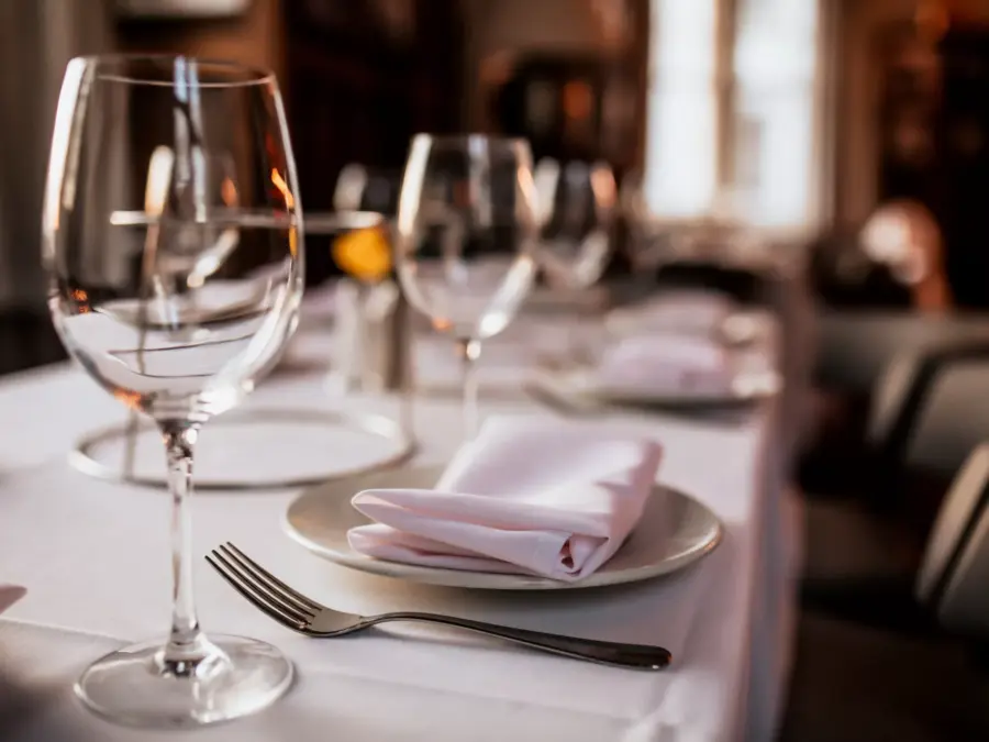 An upscale restaurant place setting with wine glasses and a linen napkin
