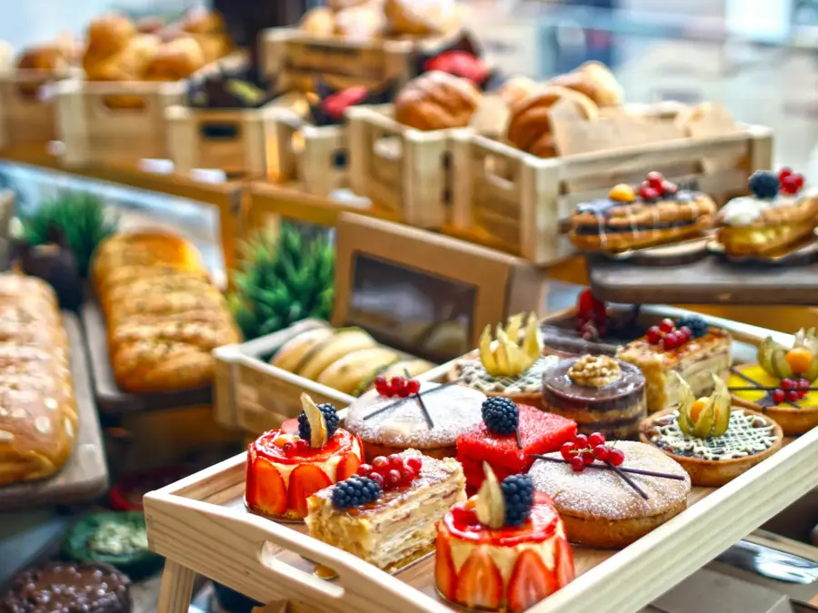 A catered dessert table of mini pastries, fruit tarts and petits fours