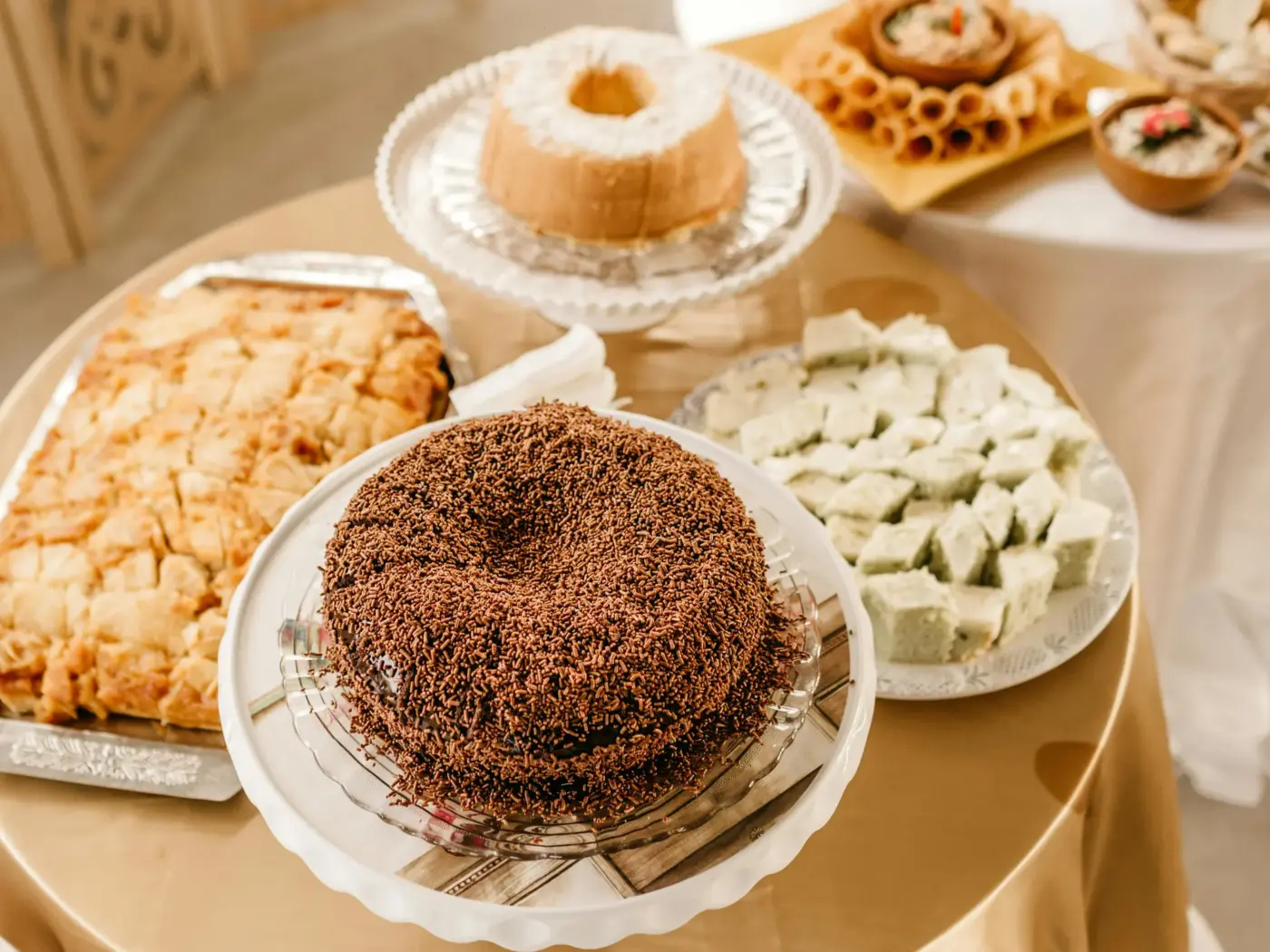A banquet dessert table with a chocolate-covered cake and assorted confections