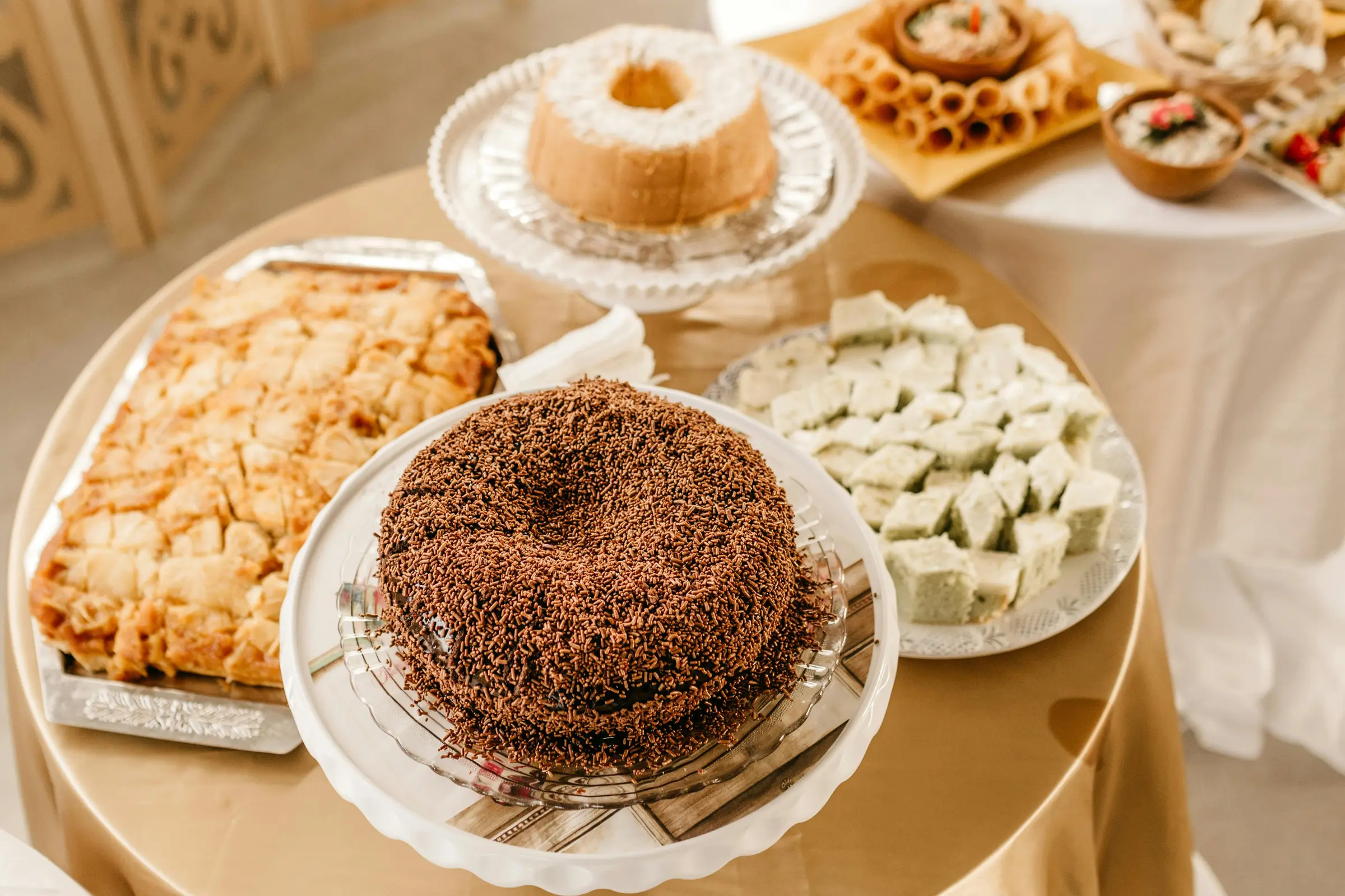 A banquet dessert table with a chocolate-covered cake and assorted confections