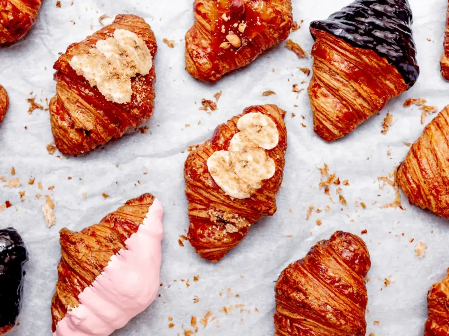 Filled croissants topped with banana, cream and pink glaze