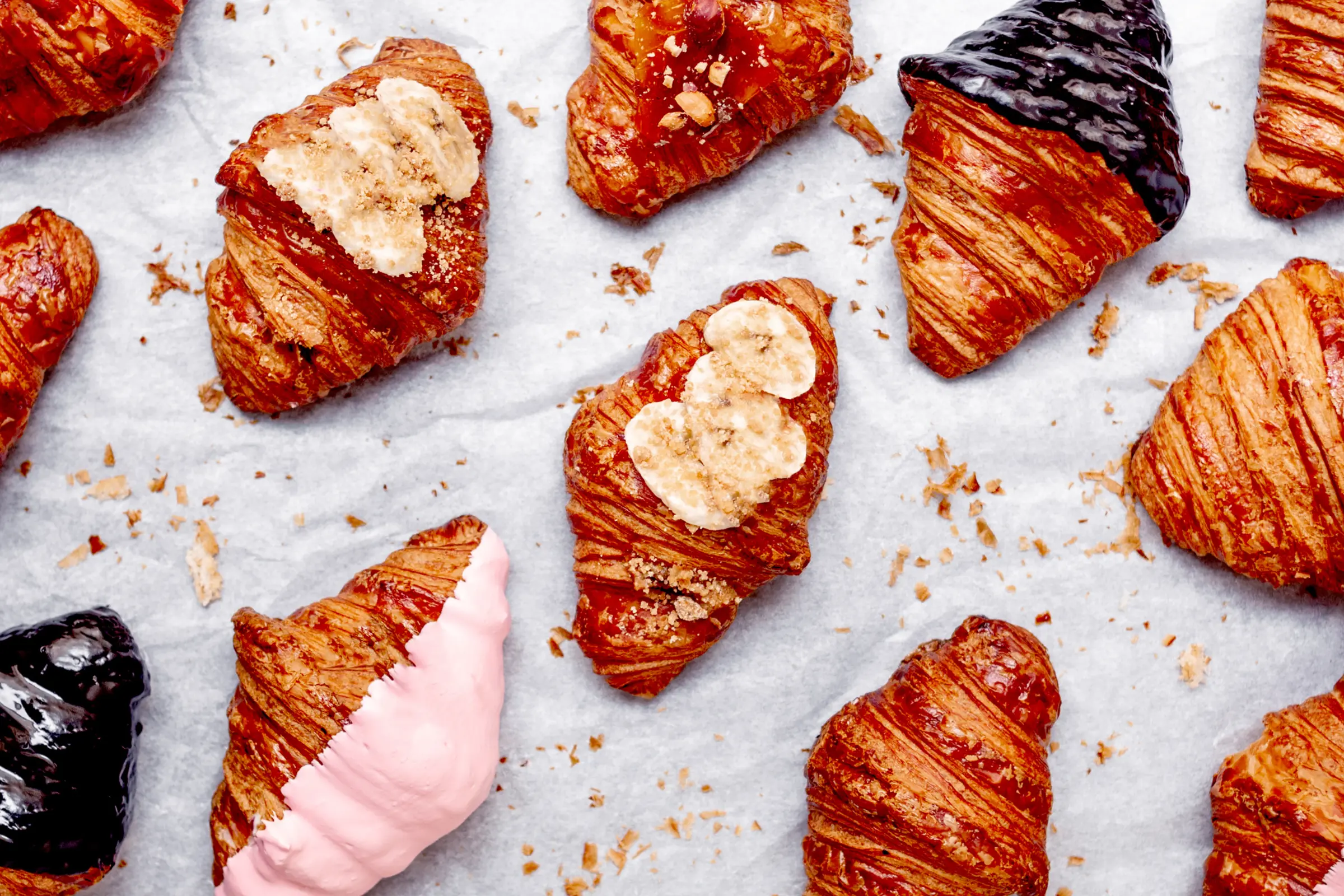 Filled croissants topped with banana, cream and pink glaze